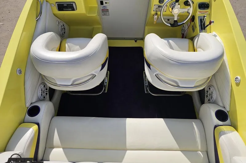 Slide: The Image of 2005 Baja 25 Outlaw boat interior with yellow and white seating, steering wheel, and speakers. - 62