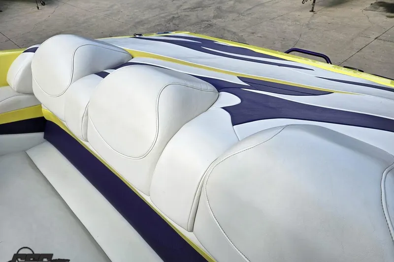 Slide: The Image of 2005 Baja 25 Outlaw boat interior with white, yellow, and purple upholstery design. - 63
