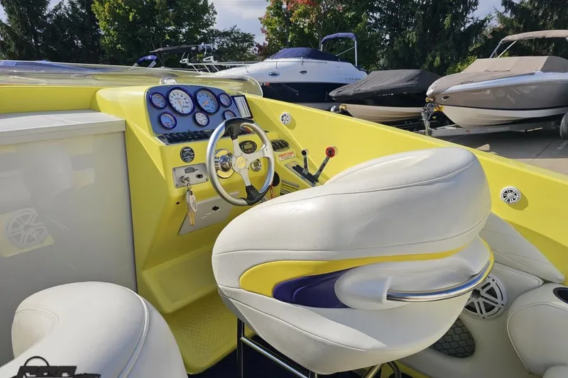 Slide: The Image of 2005 Baja 25 Outlaw boat interior with yellow dashboard and white seating. - 65