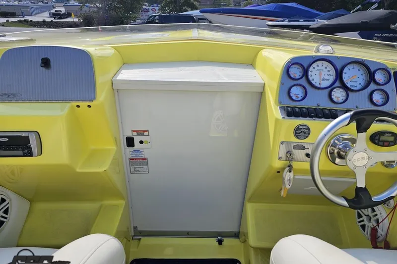 Slide: The Image of 2005 Baja 25 Outlaw boat dashboard with yellow accents and multiple gauges. - 73