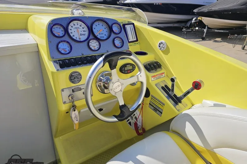 Slide: The Image of 2005 Baja 25 Outlaw boat cockpit with yellow dashboard and steering wheel. - 78