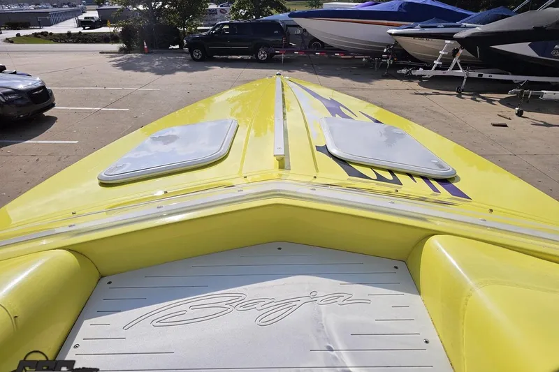 Slide: The Image of 2005 Baja 25 Outlaw boat, yellow exterior, docked with other boats in a marina. - 81