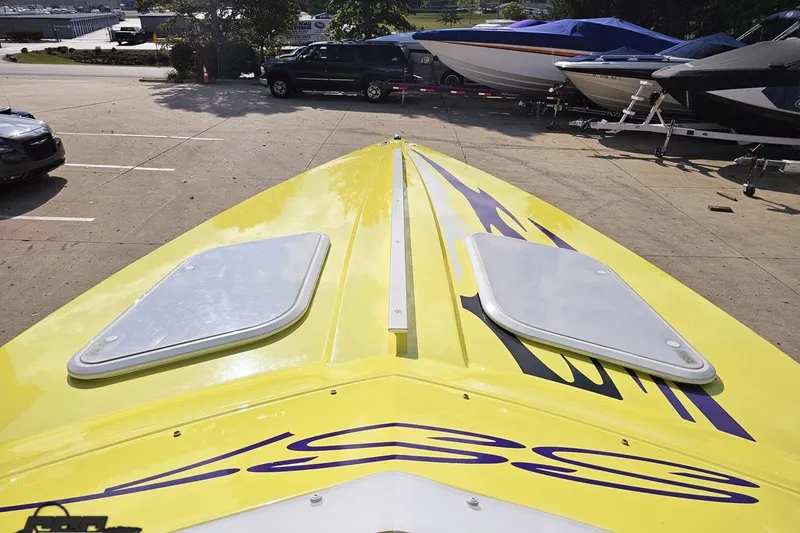 Slide: The Image of Yellow 2005 Baja 25 Outlaw boat with hatches, parked in a marina lot. - 82