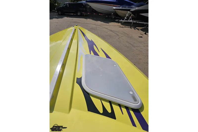 Slide: The Image of Yellow 2005 Baja 25 Outlaw boat with vibrant graphics on deck. - 83