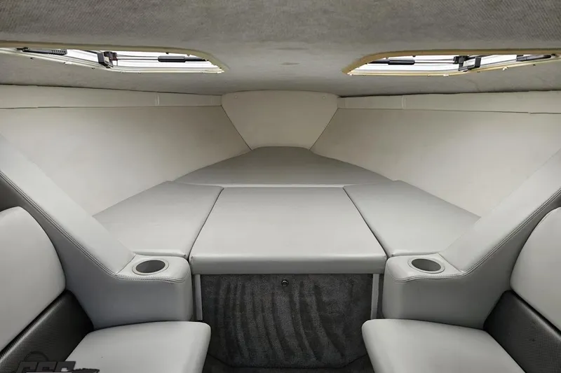 Slide: The Image of 2005 Baja 25 Outlaw cabin interior with gray upholstery and cup holders. - 85