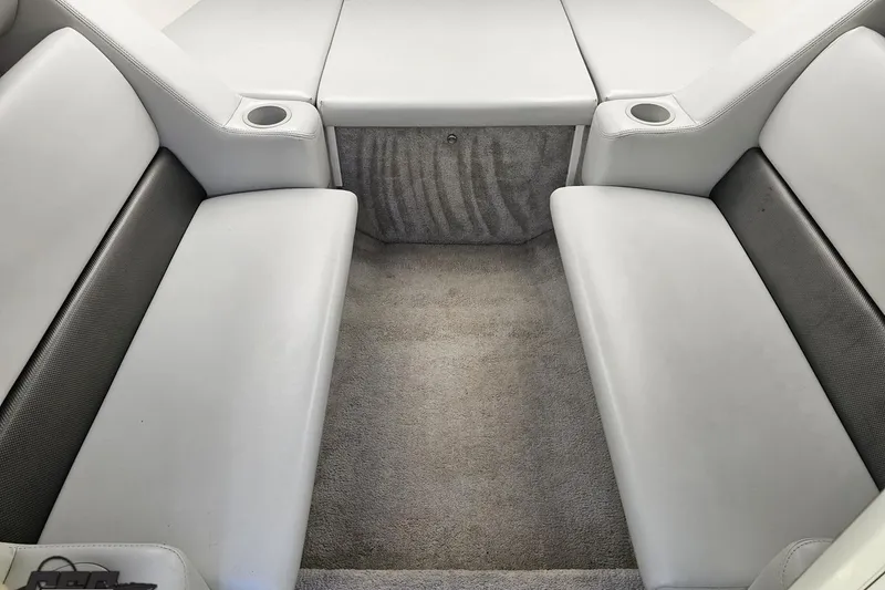 Slide: The Image of 2005 Baja 25 Outlaw boat interior with gray seating and carpeted flooring. - 86