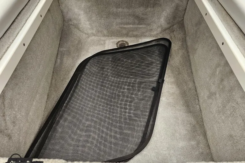 Slide: The Image of 2005 Baja 25 Outlaw boat interior storage compartment with black mesh cover. - 90