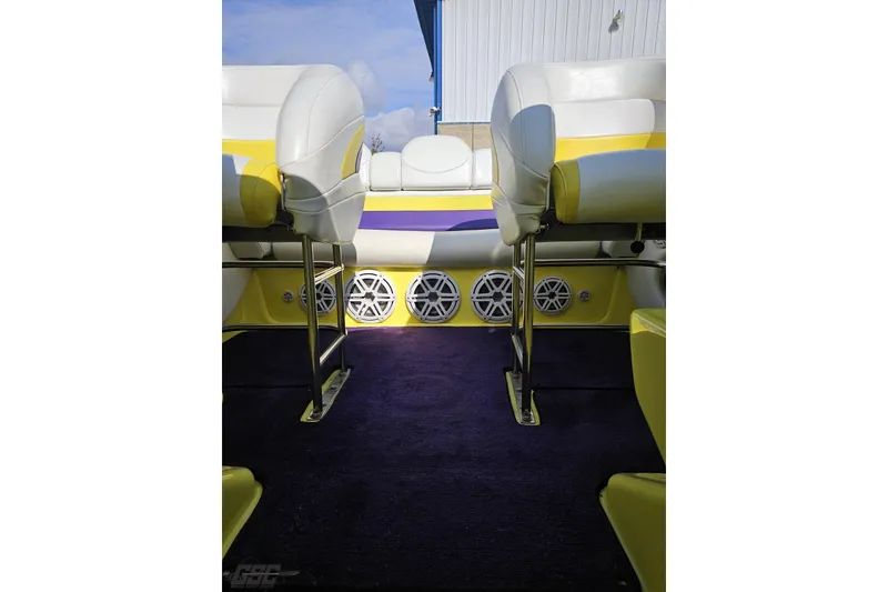 Slide: The Image of 2005 Baja 25 Outlaw boat interior with white and yellow seating, visible speakers. - 93