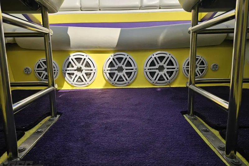Slide: The Image of Interior of 2005 Baja 25 Outlaw boat with multiple audio speakers and purple carpet. - 95