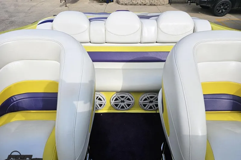 Slide: The Image of 2005 Baja 25 Outlaw boat interior with white, yellow, and purple seating. - 96