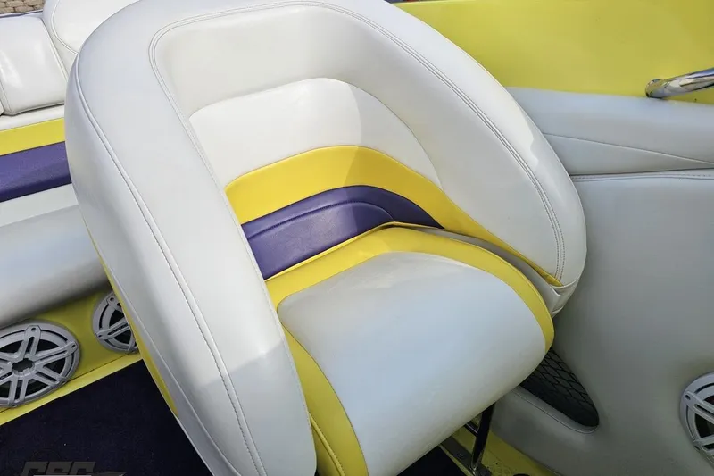 Slide: The Image of 2005 Baja 25 Outlaw boat seat with white, yellow, and purple upholstery. - 99