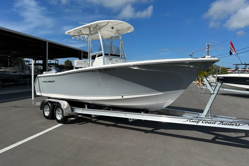 The Image of 2016 Sea Hunt Triton 225 boat on trailer under clear blue sky. - 1