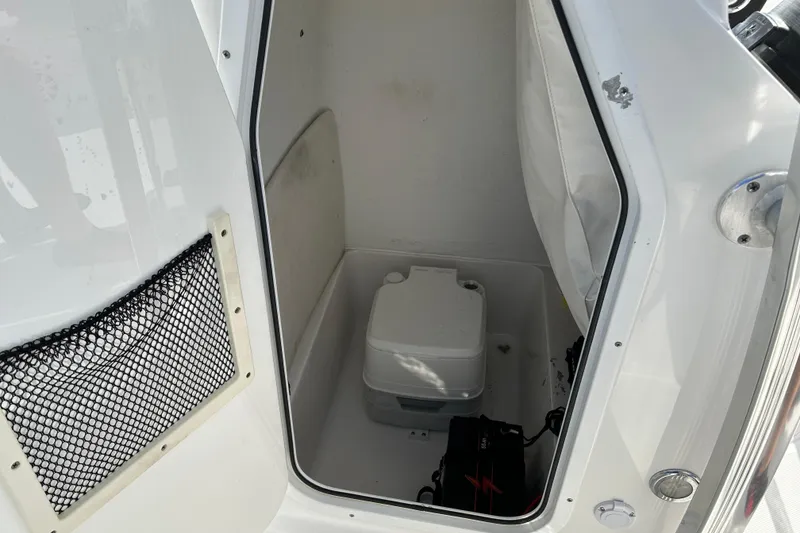Slide: The Image of Interior of 2016 Sea Hunt Triton 225 boat showing storage compartment and portable toilet. - 15