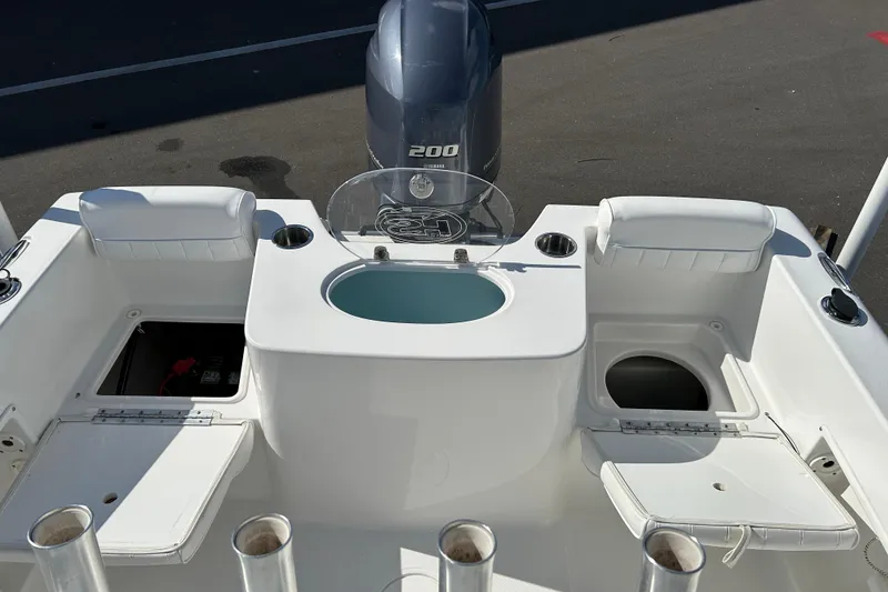 Slide: The Image of 2016 Sea Hunt Triton 225 boat interior with seating, storage, and motor. - 18