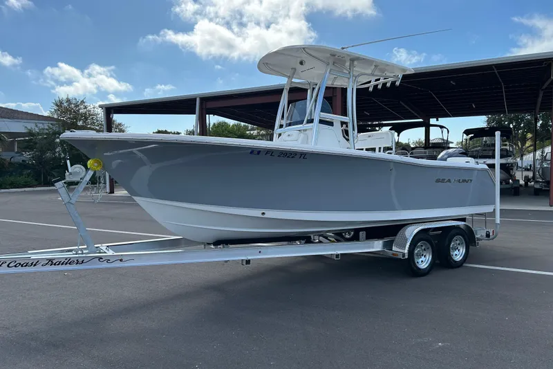 Slide: The Image of 2016 Sea Hunt Triton 225 boat on trailer, parked outdoors under a clear sky. - 5
