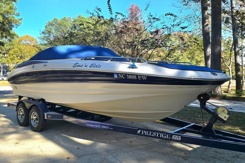 Slide: The Image of 2006 Azure AZ 220 boat on trailer, parked outdoors with trees in background. - 3