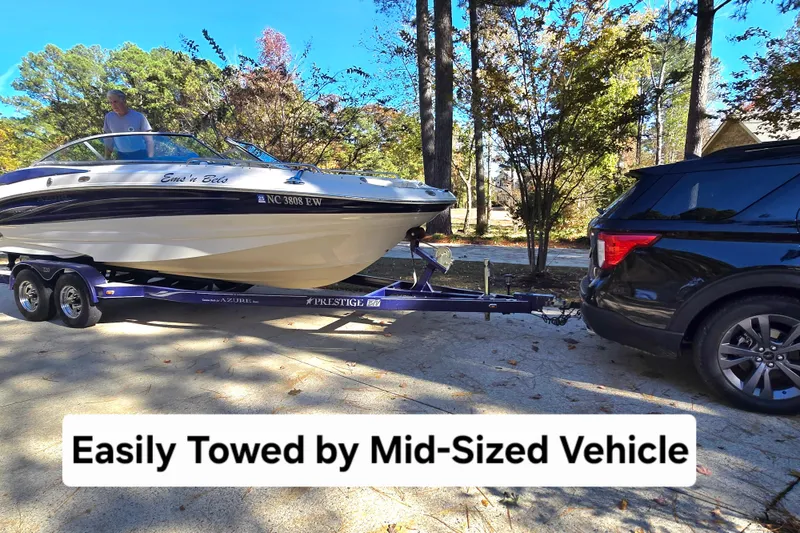 Slide: The Image of Mid-sized vehicle towing 2006 Azure AZ 220 boat on trailer in wooded area. - 5