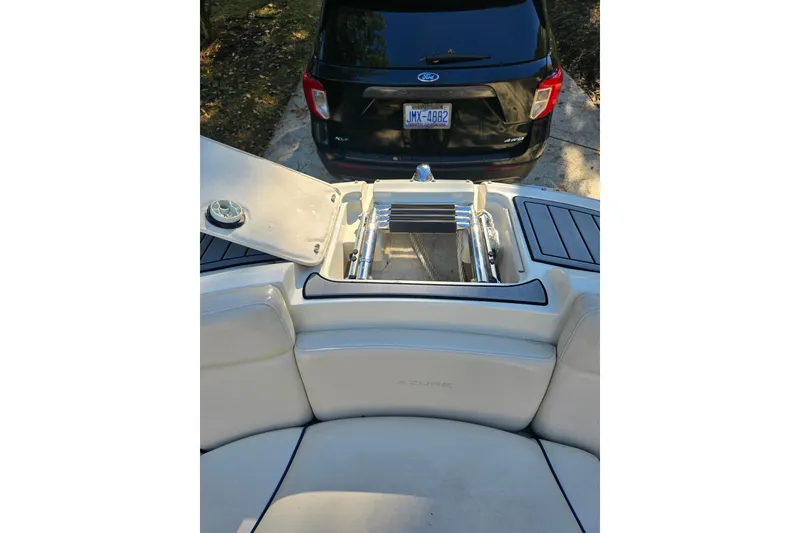 Slide: The Image of 2006 Azure AZ 220 boat with open hatch, ladder, and parked car in background. - 8