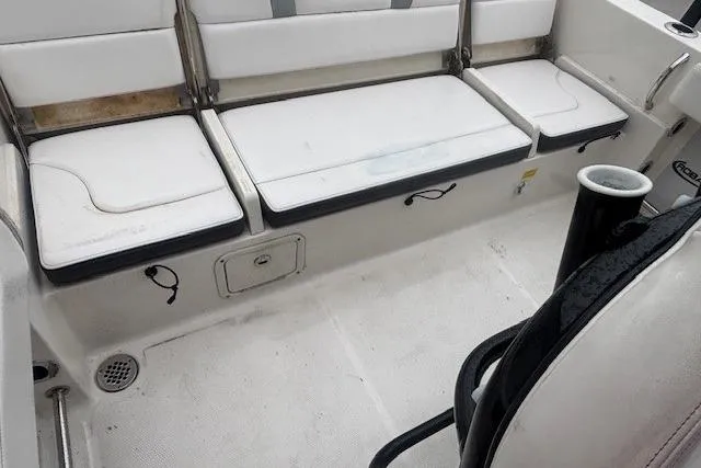 Slide: The Image of 2021 Robalo R230 Center Console boat seating with white cushions and storage compartments. - 12