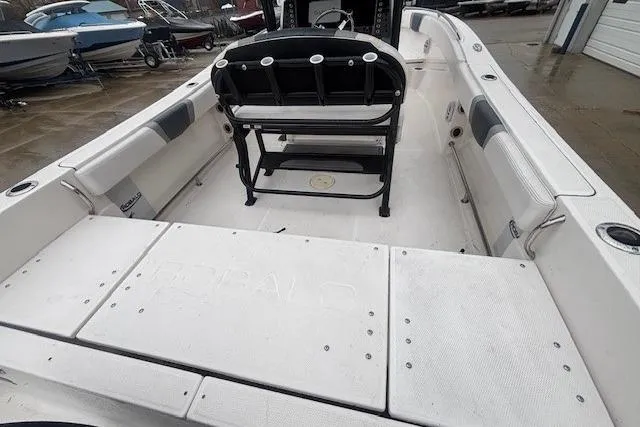 Slide: The Image of 2021 Robalo R230 Center Console boat on trailer, black hull, overcast sky. - 18