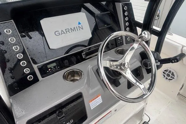 Slide: The Image of 2021 Robalo R230 Center Console boat on trailer, parked outside a warehouse. - 5