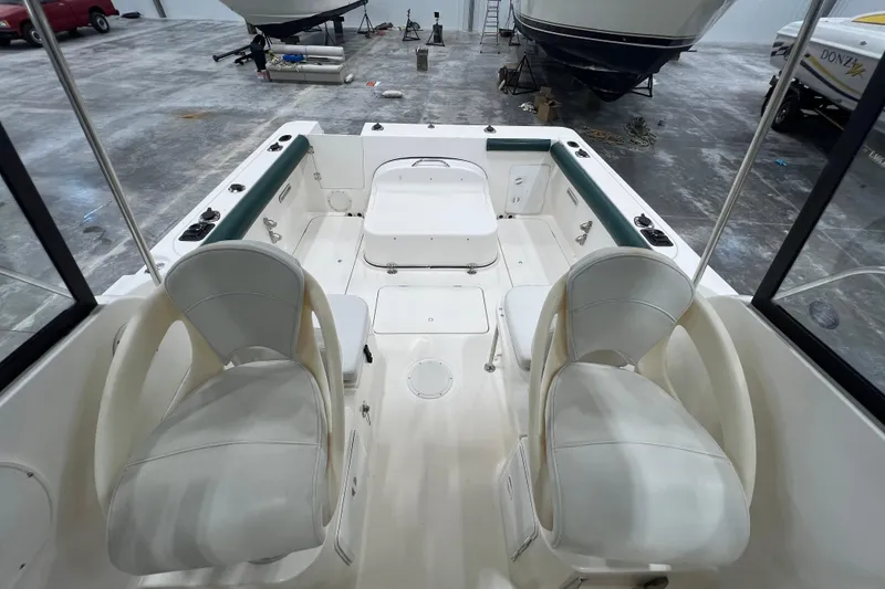 Slide: The Image of 2006 Trophy 2352 WA boat interior with seating and storage, in a warehouse setting. - 13