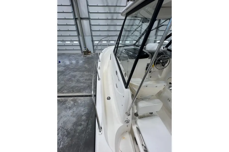 Slide: The Image of 2006 Trophy 2352 WA boat interior, showcasing helm and seating in a spacious garage. - 15