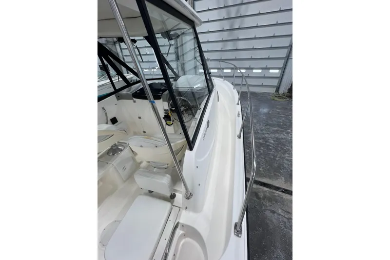 Slide: The Image of 2006 Trophy 2352 WA boat interior with seating and steering wheel in a garage. - 16