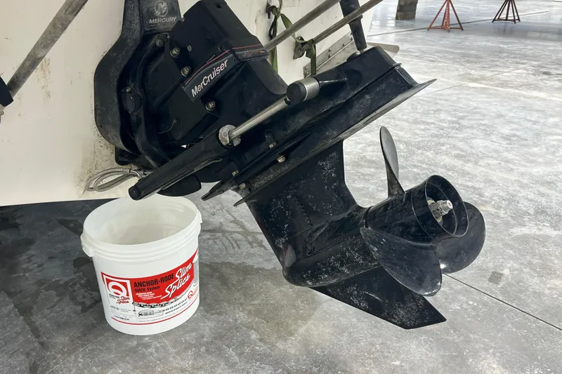 Slide: The Image of 2006 Trophy 2352 WA boat propeller and MerCruiser engine with a bucket nearby. - 20