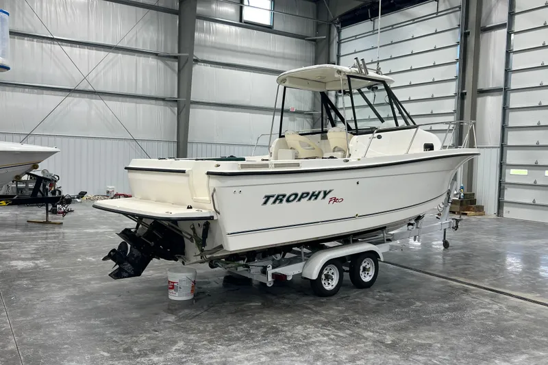Slide: The Image of 2006 Trophy 2352 WA boat on trailer in a spacious indoor storage facility. - 3