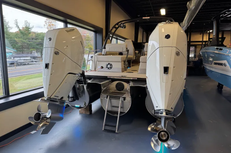 The Image of 2026 Tahoe Pontoon Grand Tahoe LTD Quad Lounge with dual outboard motors in showroom. - 0