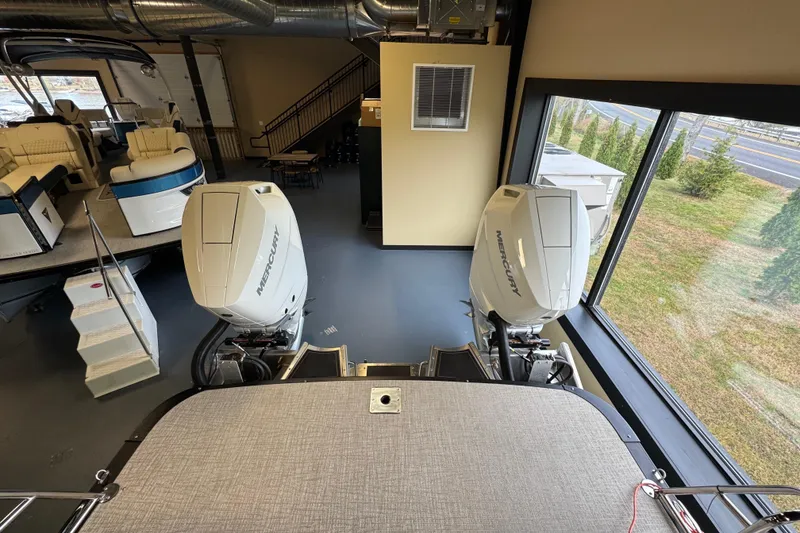 Slide: The Image of 2026 Tahoe Pontoon Grand Tahoe LTD Quad Lounge with dual Mercury engines in showroom. - 2