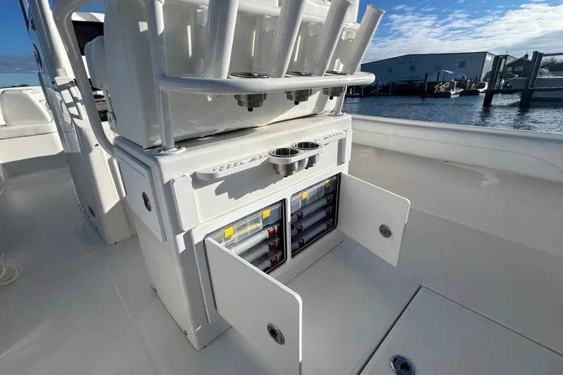 Slide: The Image of 2022 Regulator 25 boat interior with open storage compartments and rod holders. - 13