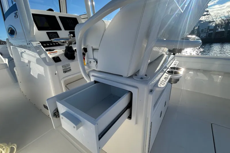 Slide: The Image of 2022 Regulator 25 boat interior with open storage drawer and control panel. - 14