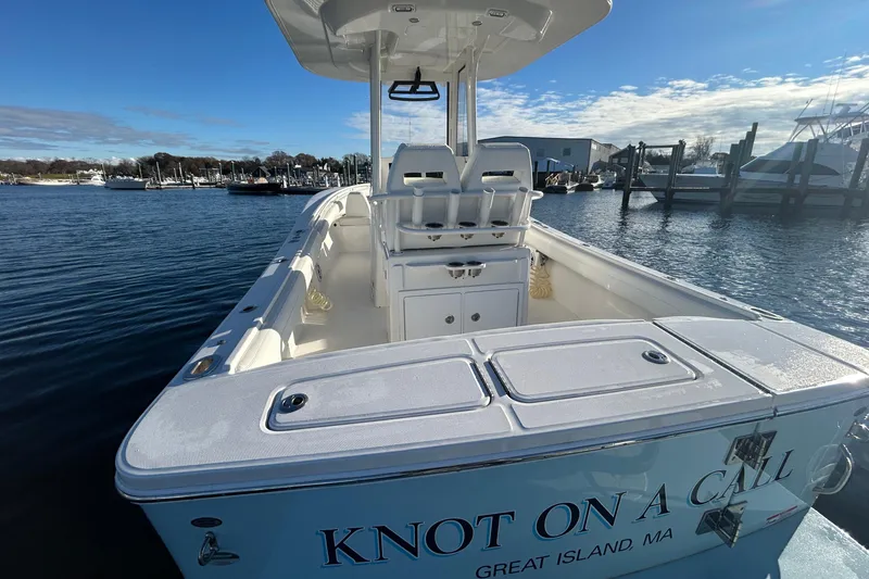 Slide: The Image of 2022 Regulator 25 boat docked, featuring spacious deck and seating, named "Knot On A Call." - 15