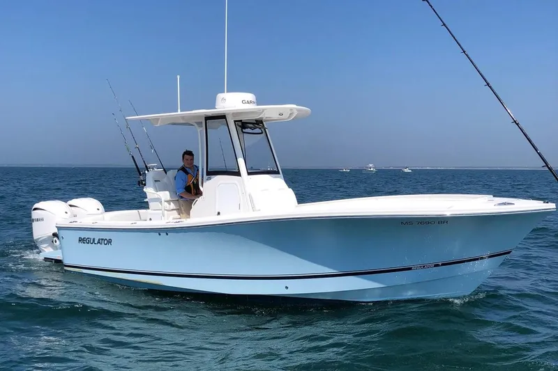 Slide: The Image of 2022 Regulator 25 boat with Yamaha engines in a marina setting. - 2