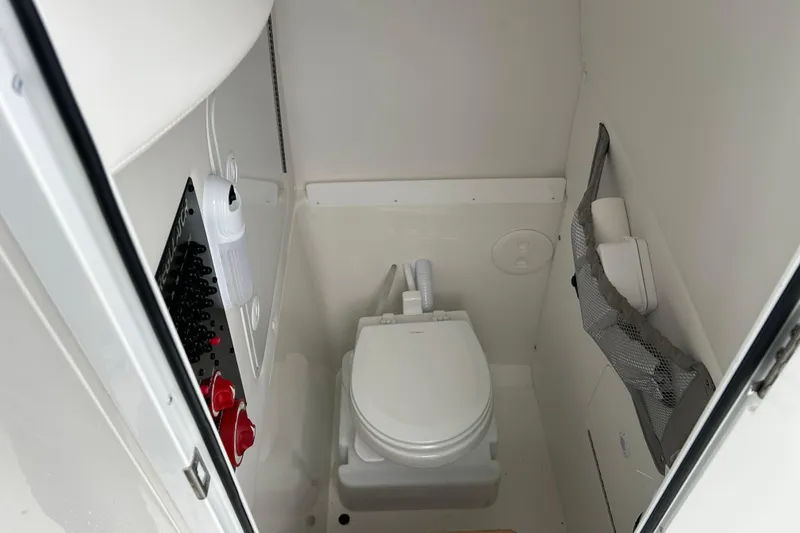 Slide: The Image of 2022 Regulator 25 boat interior with compact marine toilet and storage. - 22