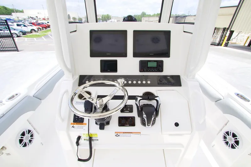 Slide: The Image of 2022 Regulator 25 boat cruising near marina with Yamaha engine, clear blue sky. - 4