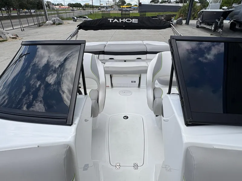 Slide: The Image of 2019 Tahoe 700 boat interior with seating and windshield, parked outdoors. - 15