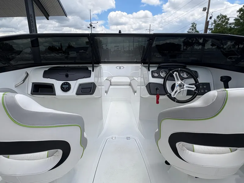 Slide: The Image of 2019 Tahoe 700 boat interior with dual seats, steering wheel, and dashboard under a cloudy sky. - 9