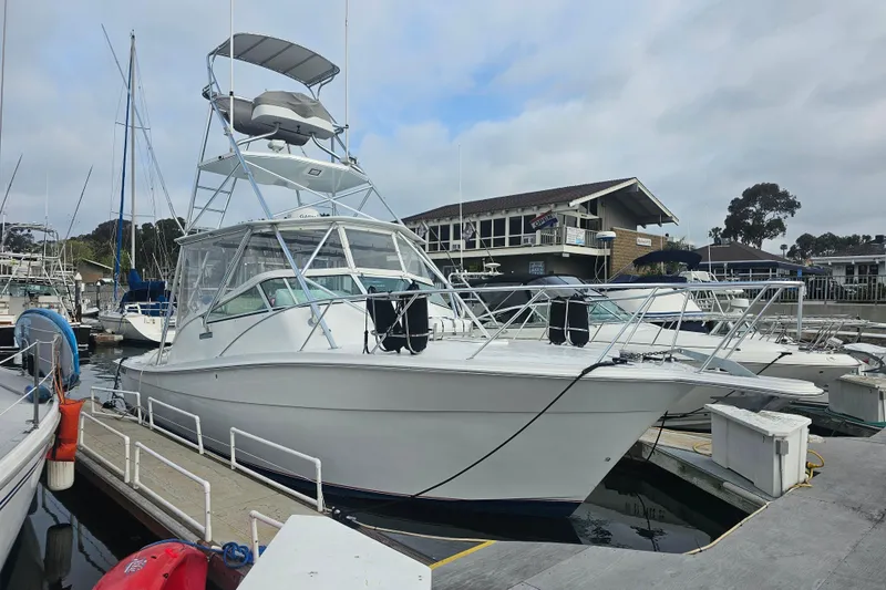 The Image of 2003 Topaz 32 Express boat docked at a marina under cloudy skies. - 0