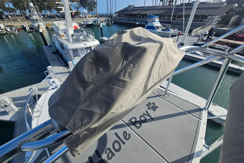 Slide: The Image of 2003 Topaz 32 Express boat docked at marina, covered equipment, "Haole Boy" text on deck. - 12