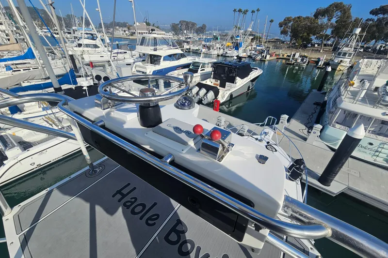 Slide: The Image of Helm of 2003 Topaz 32 Express yacht in marina, surrounded by boats. - 15