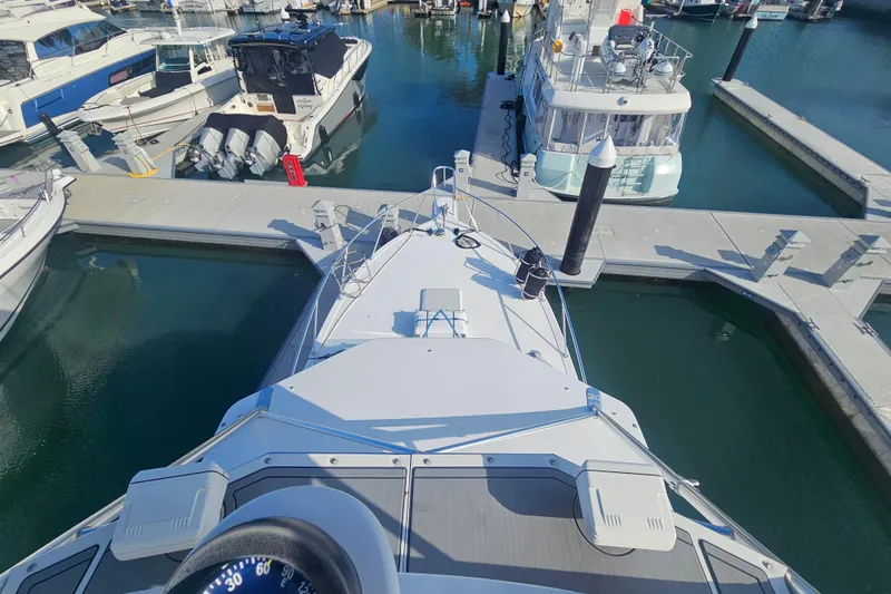 Slide: The Image of Bow view of a 2003 Topaz 32 Express yacht docked in a marina. - 16