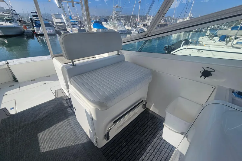 Slide: The Image of 2003 Topaz 32 Express boat interior with seating and marina view. - 24