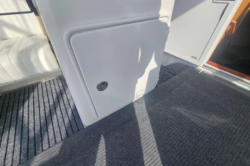 Slide: The Image of 2003 Topaz 32 Express boat interior with carpeted flooring and storage compartment. - 26