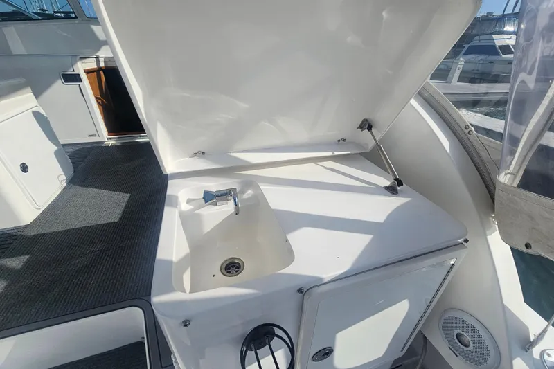 Slide: The Image of 2003 Topaz 32 Express boat interior with open sink compartment and carpeted flooring. - 31