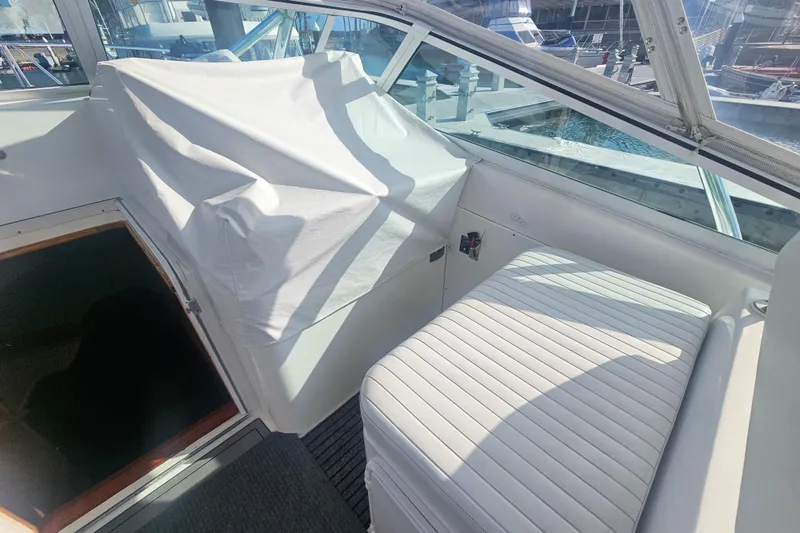 Slide: The Image of Interior of 2003 Topaz 32 Express boat with covered controls and seating. - 32