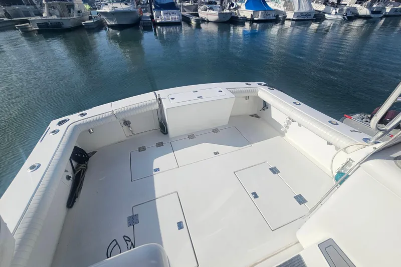 Slide: The Image of 2003 Topaz 32 Express boat deck with marina view, featuring spacious seating and storage. - 33