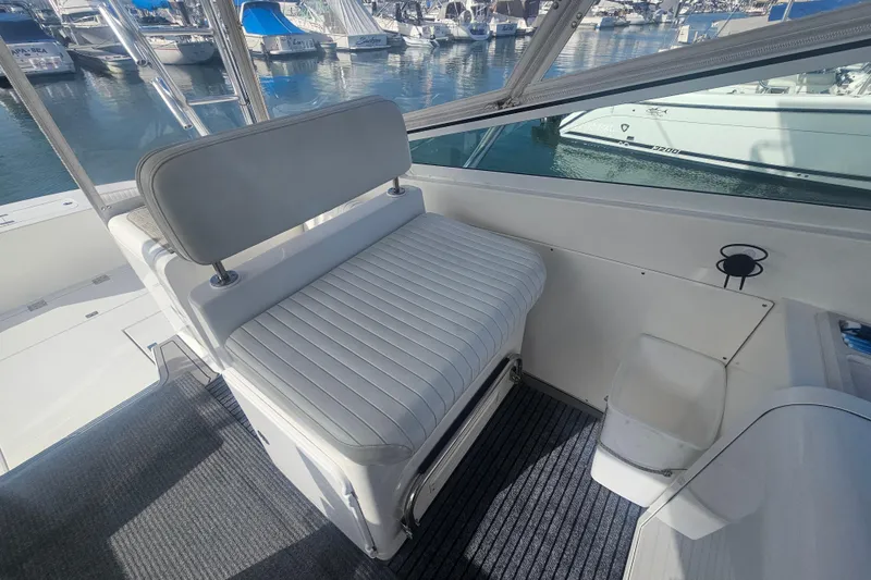 Slide: The Image of 2003 Topaz 32 Express boat interior with cushioned seating and marina view. - 44